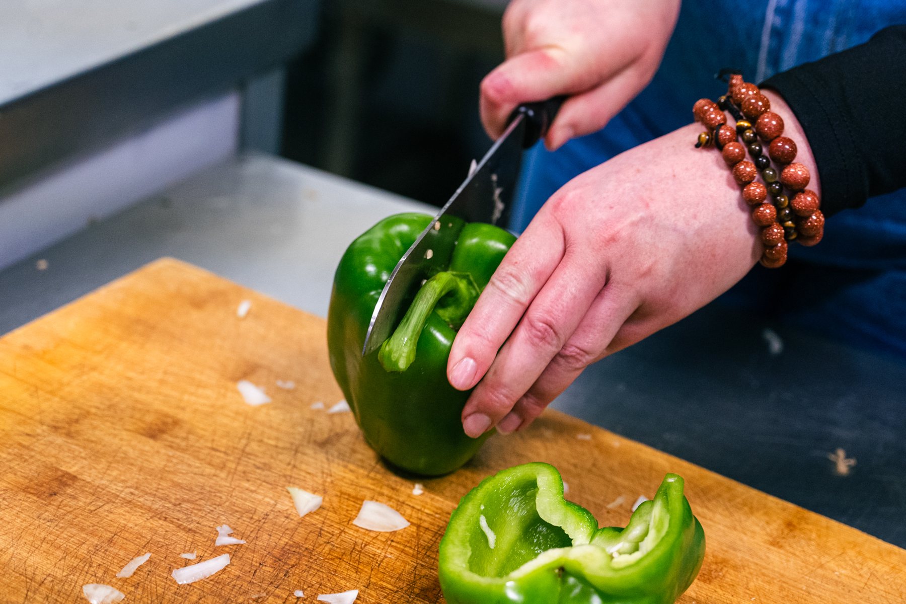 Un bénévole coupe des poivrons en cuisine